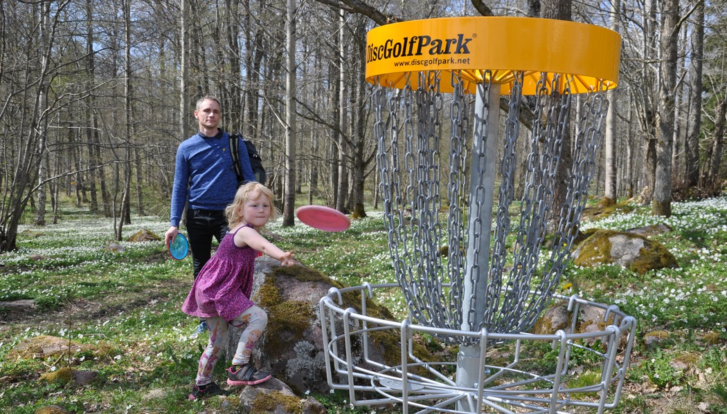 En man och flicka som spelar discgolf.