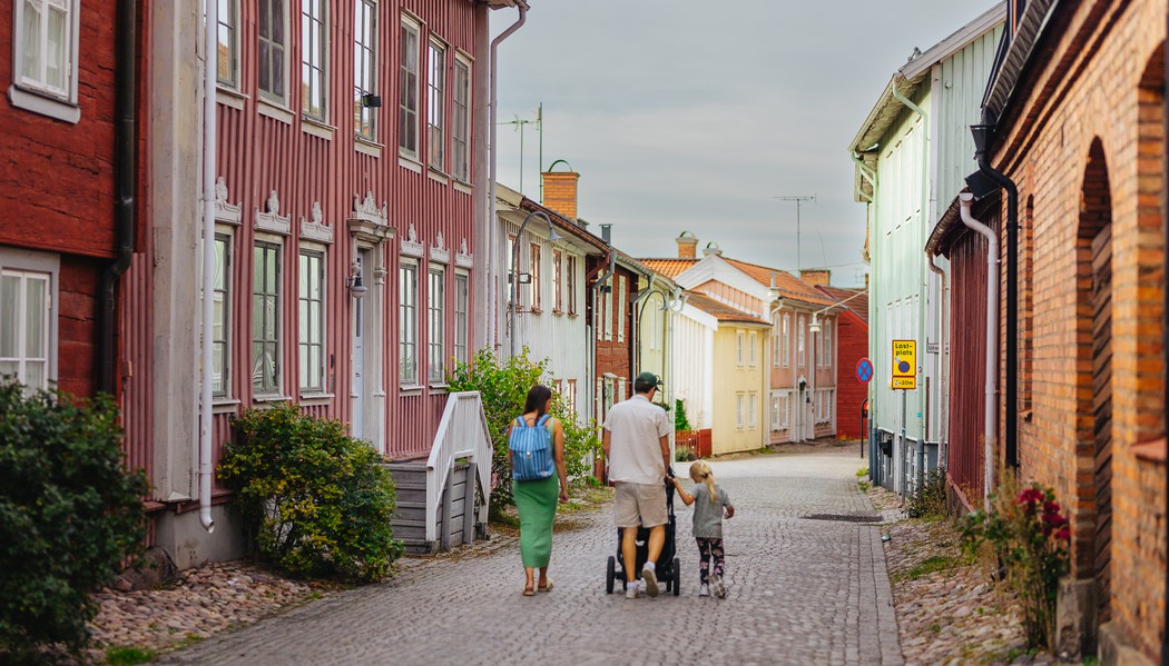 Familj som går genom trästaden