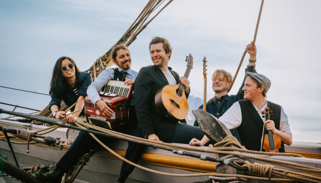 Gruppbild på bandet i en båt