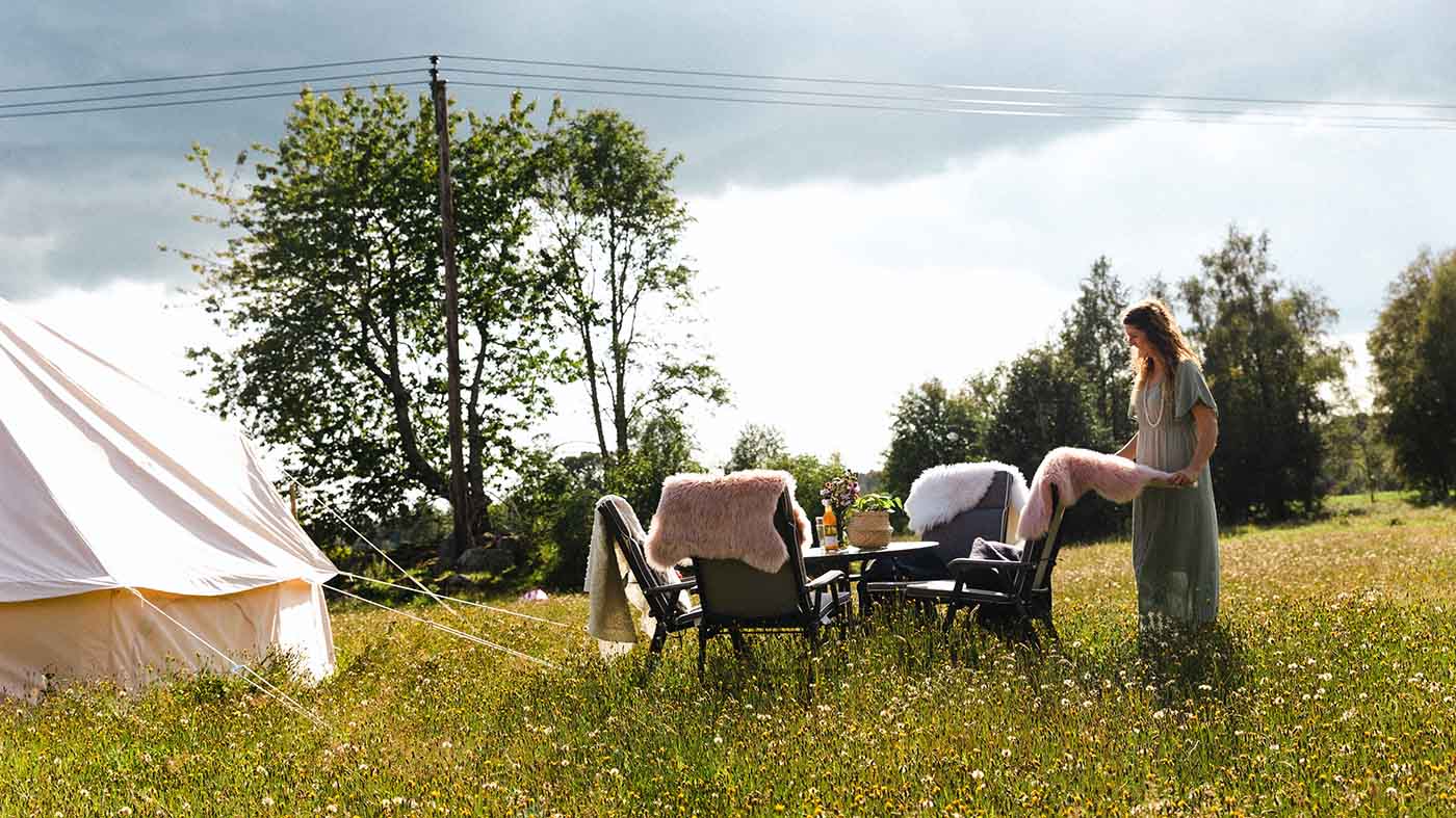 Trädgårdsgrupp på äng vid tält