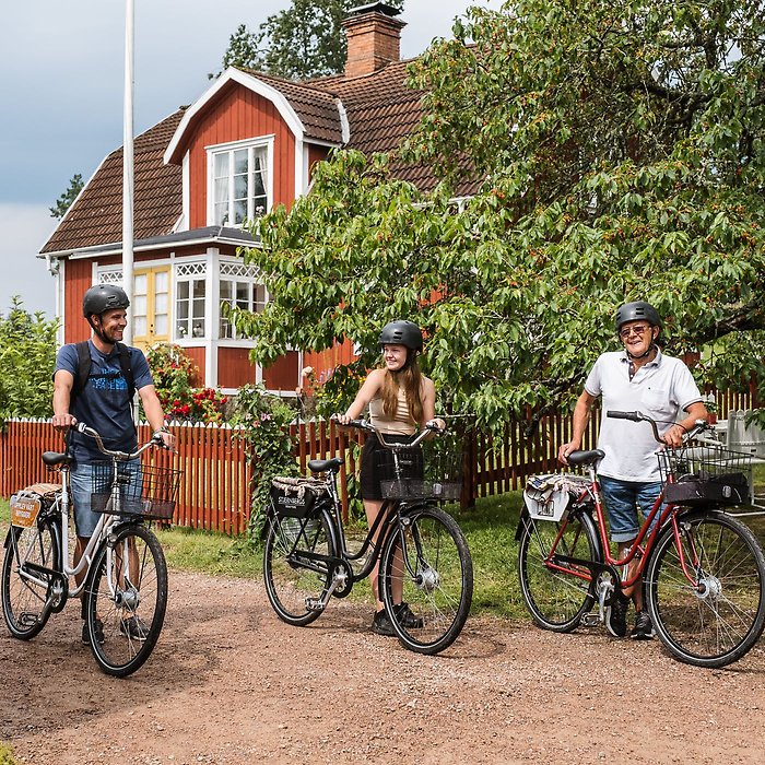 tre personer med varsin cykel, ser glada ut