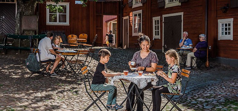 Personer som fikar i gammaldags miljö.